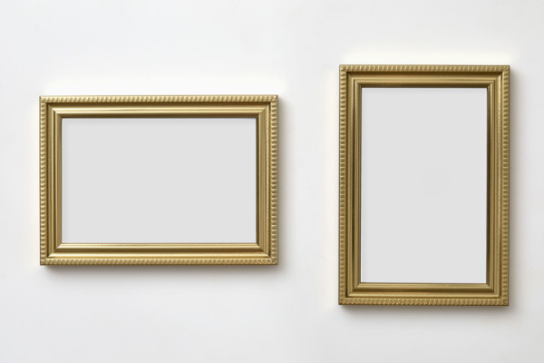 Gold decorative picture frames on white wall