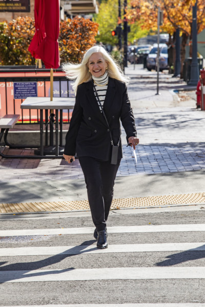USA, Idaho, Boise, Smiling senior blond businesswoman crossing downtown street