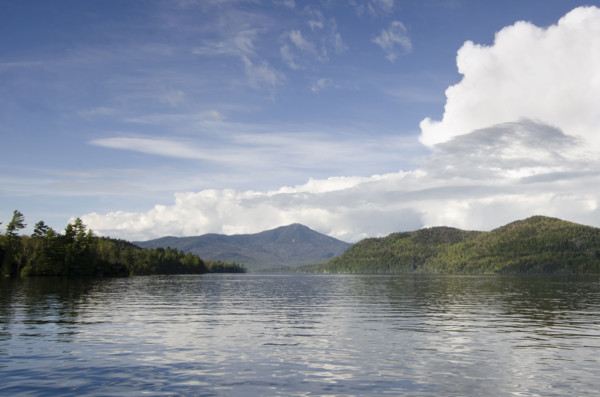 Puffy clouds over calm lake Placid . Lake Placid, New York State, USA.