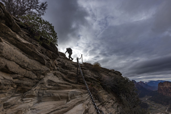 Low angle view of female hiker climbing top of Angels Landing. , Utah, USA.