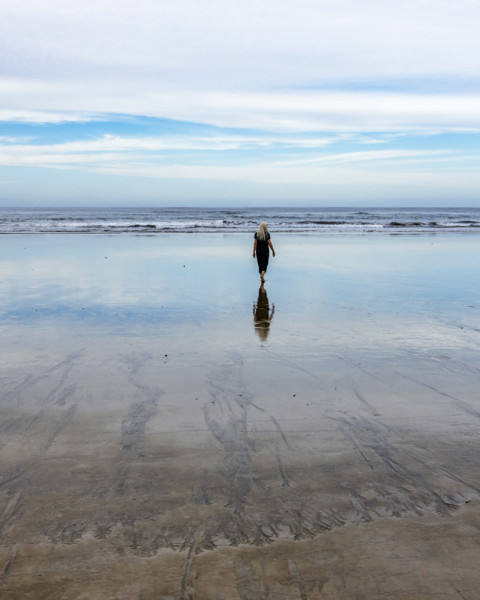Rear view of senior woman walking on beach at dawn. , Guanacaste, Costa Rica.