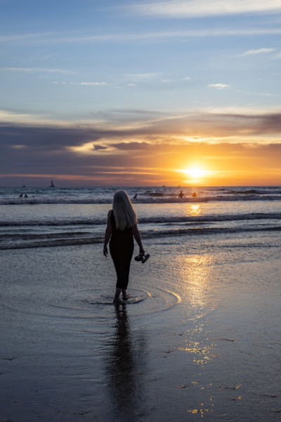 Rear view of woman walking on beach at sunset. , Guanacaste, Costa Rica.