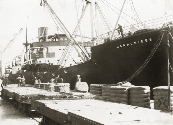 Bogies and SS Harmonides. Cranes onboard SS Harmonides prepare to lower a power bogie onto the
