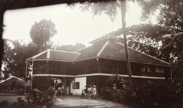 Colonial bungalow, Burma (Myanmar). Horse-drawn carriages wait in the driveway outside a large