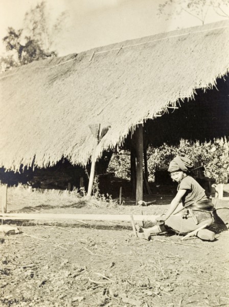 A Kachin woman weaving. A Kachin women in traditional dress weaves yarn by hand on a horizontal