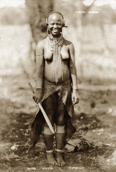 Kikuyu woman smiling. Full-length portrait of a smiling Kikuyu woman wearing neck, ear, arm and leg