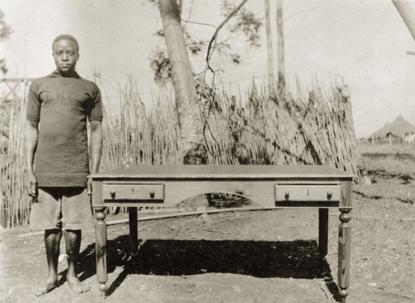 Cabinetmaker with desk. A Public Works Department employee, identified in the the caption as
