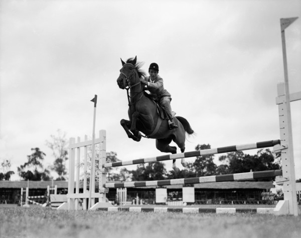 El Wak' jumps a fence. Juliet Colville jumps a fence on a horse called 'El Wak' in the juvenile