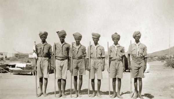 African scout group. A group of African men at a scout camp. Each carries a stick and wears a