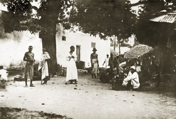 Mombasan street scene. A group of people mill about on a street corner in the centre of town.