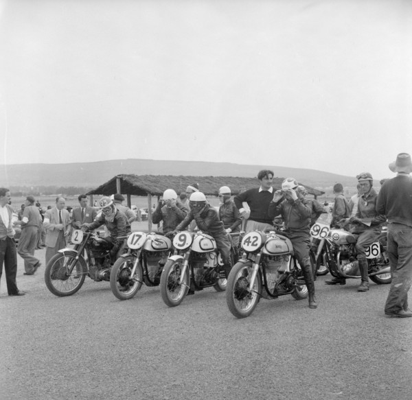 Nakuru motorcycle race. A group of riders sit astride their numbered motorcycles, adjusting their