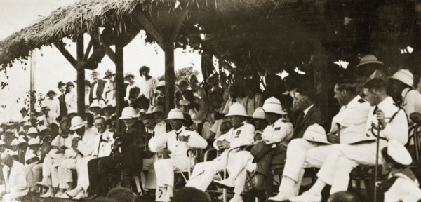 Naval officers watch a 'meke' dance. Admiral Field and other uniformed naval officers make up an