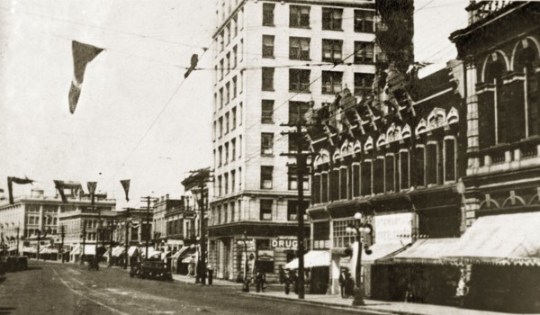 Douglas Street, Victoria. Flags hang above a quiet road lined with shopfronts identified as