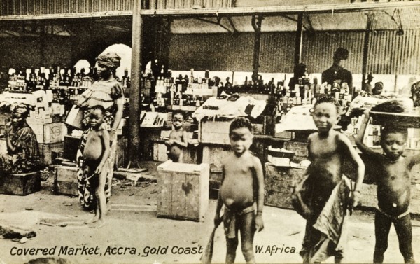Covered market in Accra. Street traders at a busy covered market in Accra sell bottles from stalls.