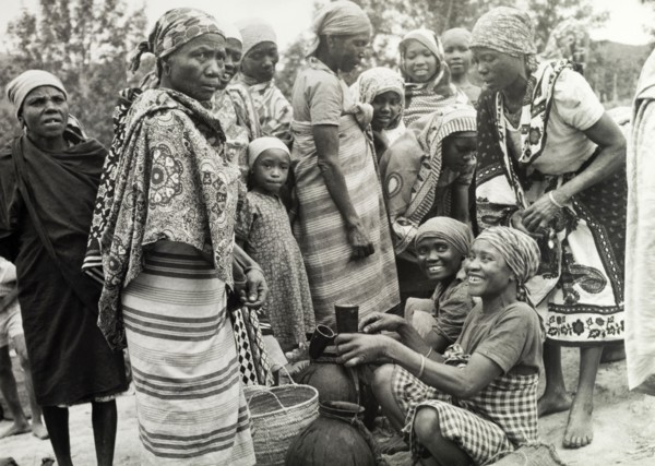 Women at a Tanganyikan market. Women laugh and chat as they examine goods at a local market.