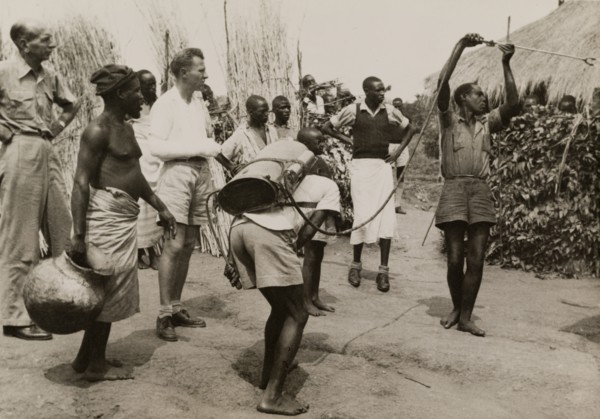 Spraying pesticide at a Congolese village. A team of men use a portable atomiser to spray
