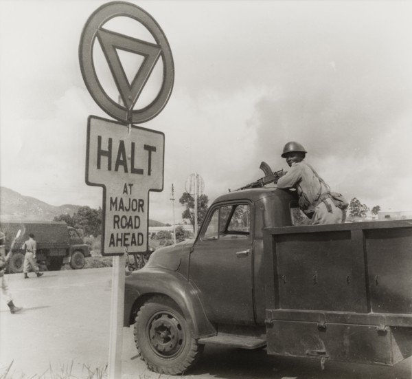An armed African soldier on the back of truck. An African soldier stands on the back of a