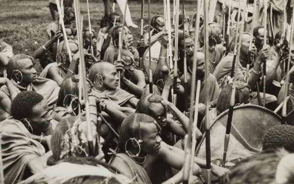 A group of Maasai warriors. A group of Maasai warriors crouch together on the ground with their