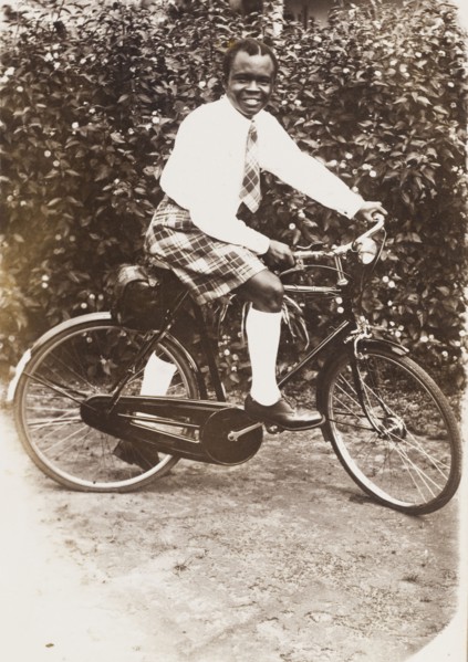 A Nigerian man in tartan. Portrait of a Nigerian man on a bicycle, dressed in a tartan kilt and