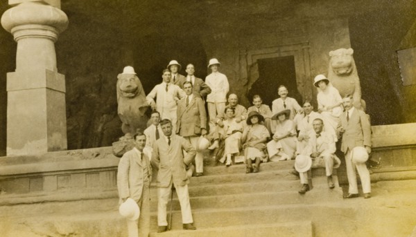 Entrance to the Elephanta Caves. A group of European visitors pose for the camera on steps outside