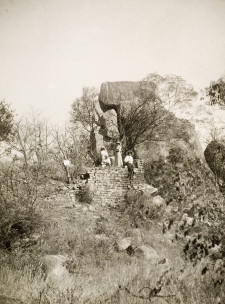 Exploring the Khami ruins. Four European women, wearing sun hats and summer dresses, explore the