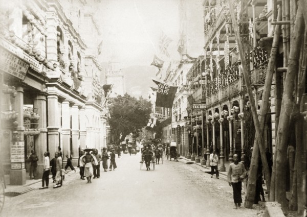 Queen's Road Central, Hong Kong. Rickshaws, pedestrians and street traders bustle about on Queen's