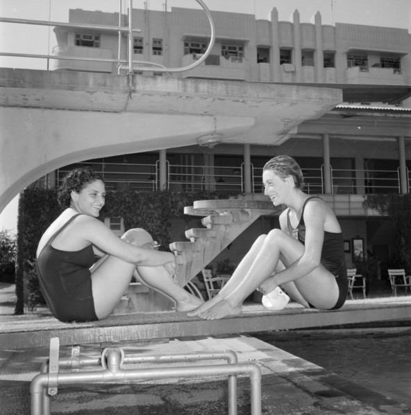 Facing the opposition. Two female swimmers competing in the 1956 Olympic Games sit facing each