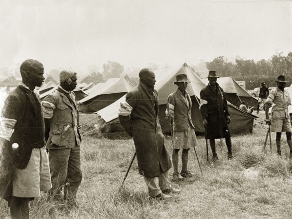 Kikuyu Home Guards in camp. Six Kikuyu Home Guards, dressed in makeshift uniforms and armed with