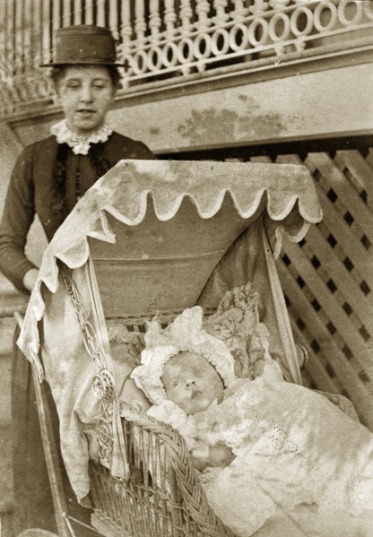 Nurse and baby at 'Nundora'. A Victorian nursemaid pushes a baby in wicker pram decorated with