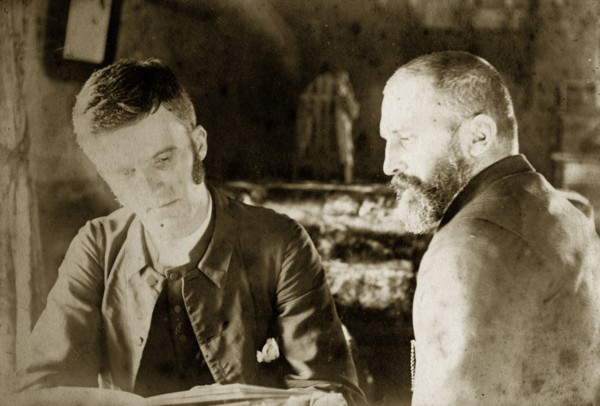 Thomas St John Parry Pughe and friend. Reverend Thomas St John Parry Pughe examines a book in the