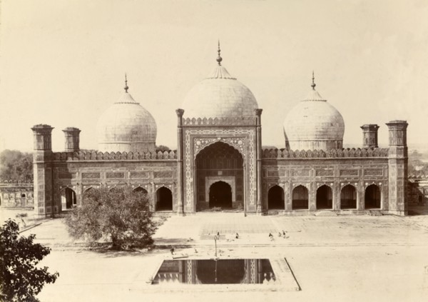 A mosque with three domes. A mosque built in typical Islamic style is decorated with features