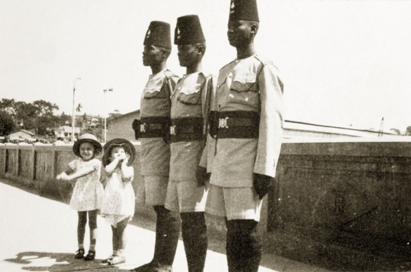 Barbara and Gwynneth with askaris. Two small European girls, Barabara and Gwynneth Wallhouse, pose