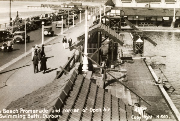 The beach promenade at Durban. Groups of people stroll along the beach promenade in Durban beside
