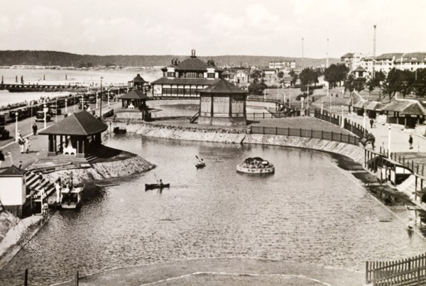 Children's outdoor pool, Durban. Two children paddle canoes on an outdoor boating pool near the