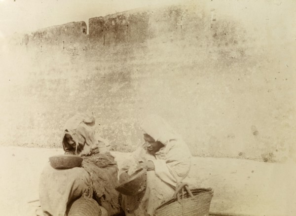 Moroccan beggars. Moroccan beggars dressed in ragged robes, sit on the street, begging bowls and
