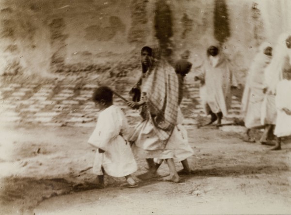 Morrocan woman and children. A young Moroccan woman, her head covered with a scarf, marshals her