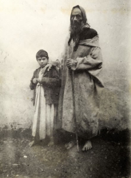 Jewish beggar, Safi. A barefoot Jewish beggar of gaunt appearance rests his hand on a young boy's