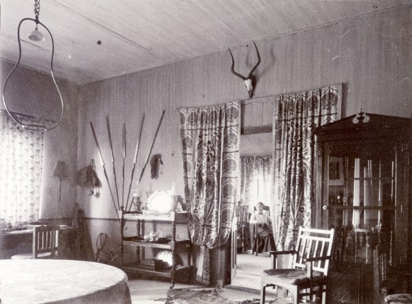 Mrs H' in the drawing room. A European woman identified as 'Mrs H', is seated in her drawing room,