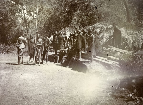 Kenyan 'road-makers'. A group of Kenyan men await instructions. They wear traditional dress and are
