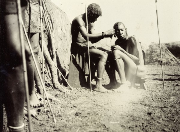 Maasai hairdressing. Maasai society is ordered by age groups and the young men shown here probably