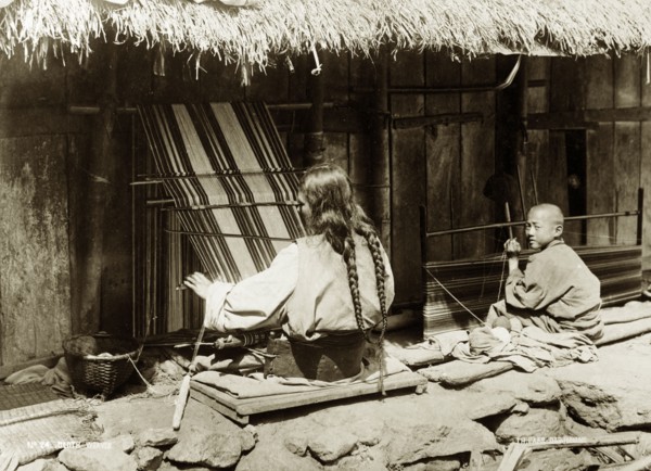 Two weavers, India. Two weavers, a woman and a child, at work on outdoor looms near Darjeeling.