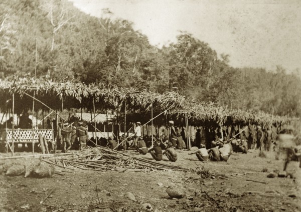 Chin tribesmen, Burma (Myanmar). A group of Chin tribesmen from the Chin Hills crouch beneath a