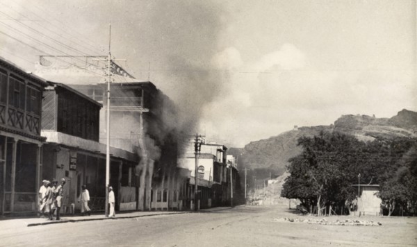 Riot damage in Aden, 1947. Smoke billows from a building in the Jewish quarter of Aden, during the