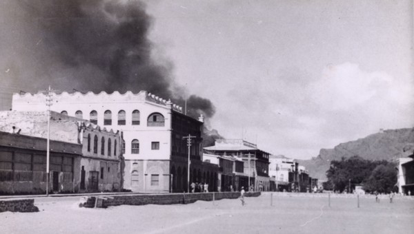 Riot damage in Aden, 1947. A plume of black smoke rises from a building in the Jewish quarter of
