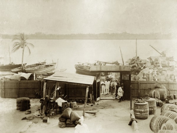 Jetty at Badagry. Cargo boats wait at a riverside jetty belonging to the African Oil Nuts Company,