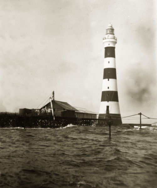 Alguada Reef lighthouse. The striped Alguada Reef lighthouse towers above rough sea waters in the