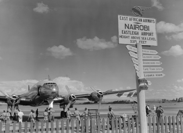 Eastleigh Airport, Nairobi. Airport staff mill around a double-propellered passenger plane that