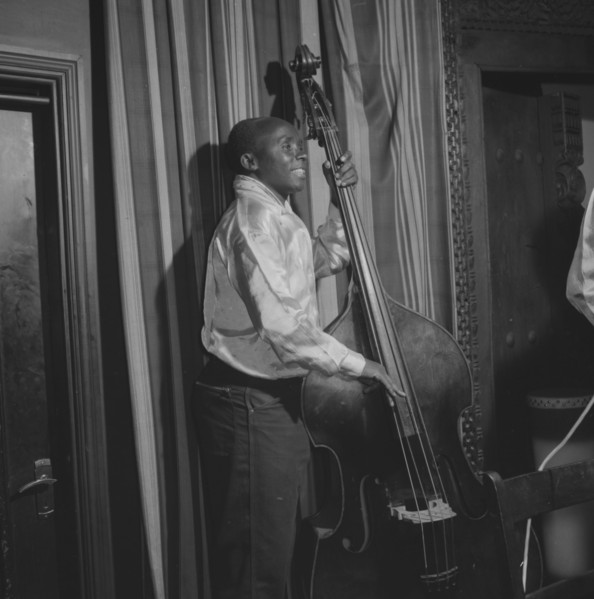 Double bass player. An African musician smiles broadly as he plays a double bass during a