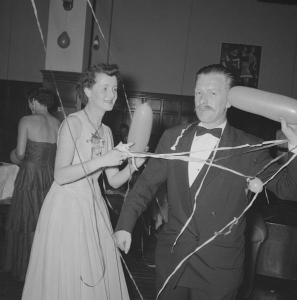 Single balloon salute. A middle-aged man at a Northern Counties dance, salutes the camera with a
