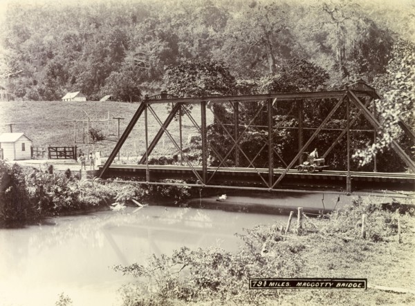 Railway track over Maggotty Bridge. A man operating a hand cart travels across a metal railway